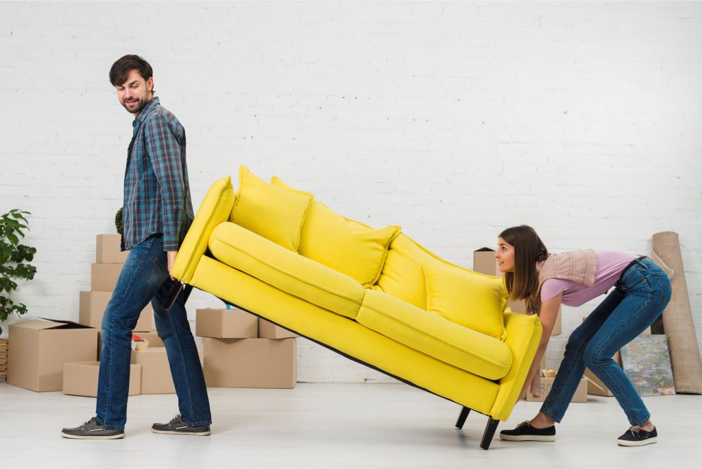 Imagem de um casal carregando um sofá